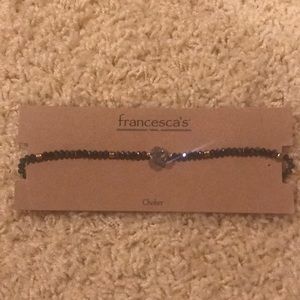 Black and gold choker with silver stone center.